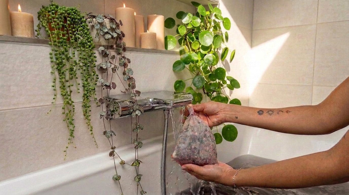 Sachet d'infusion Maison Herboriale plongé sous l'eau du bain, entouré de plantes et de bougies