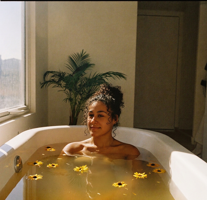 Lisa sereine dans un bain doré baigné de soleil, quelques fleurs de calendula